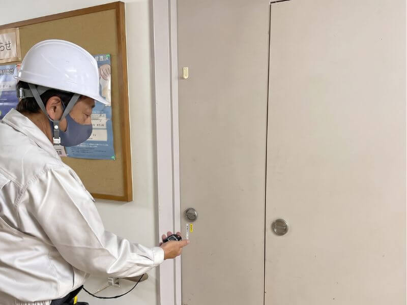 防火扉の自動閉鎖機構やラッチの噛み合わせをチェックする様子