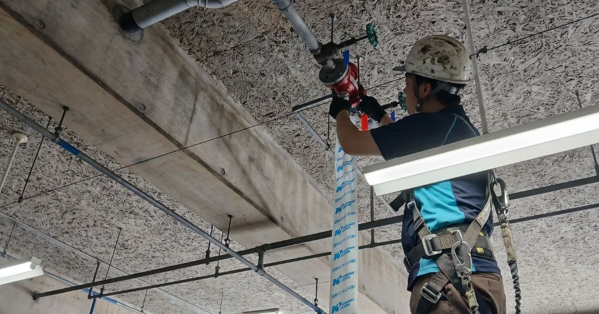 安全帯とヘルメットを着用したコーセイのスタッフが一斉開放弁のテストバルブを操作して泡消火薬剤の吐出を確認している様子