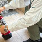 消防設備点検を行う技術者と点検済みの消火器のイメージ