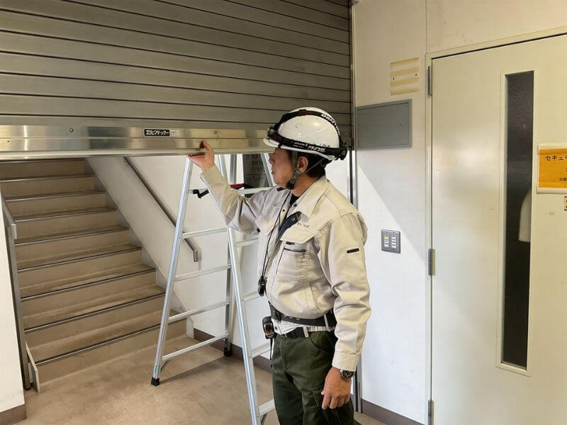 煙感知器と連動させて防火シャッターの降下作動テストを行う様子